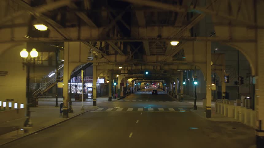 Elevated train tracks run above a city street