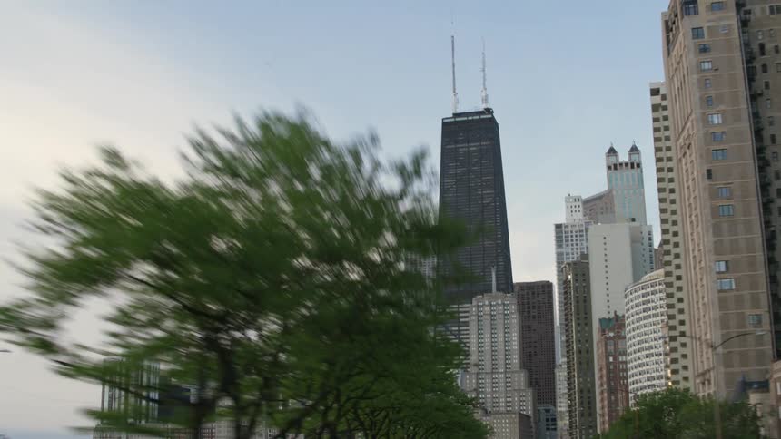 Cars driving next to the shore towards office buildings in downtown chicago