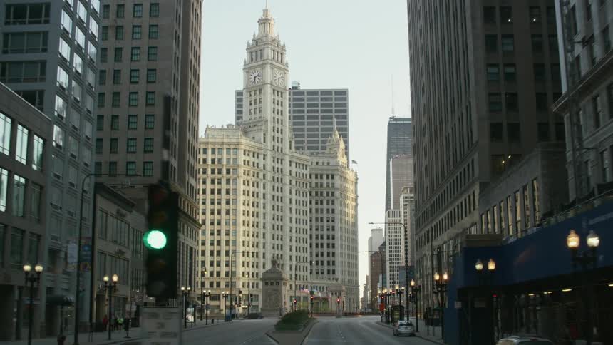 A city street with offices and businesses and pedestrians walking and cars driving