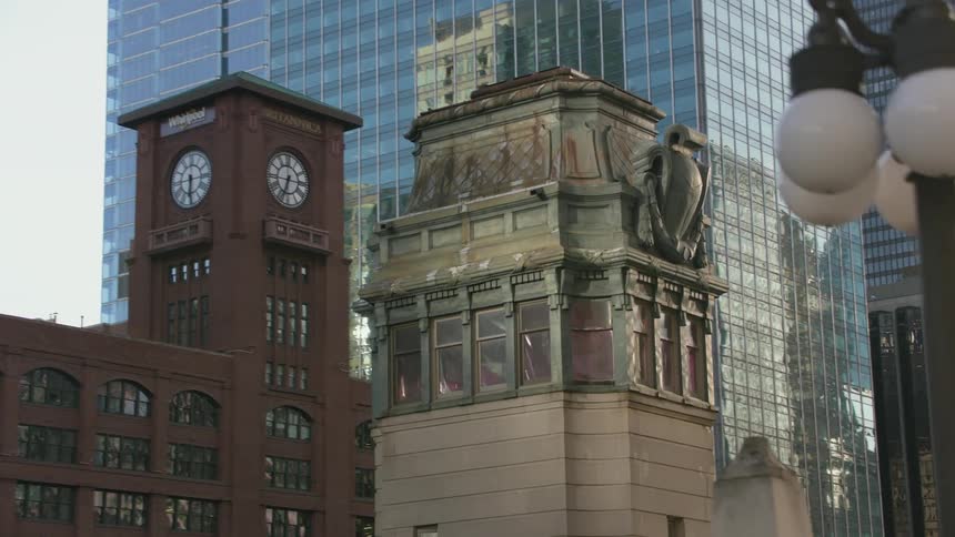 Ornate top of a tower surrounded by skyscrapers in the city downtown