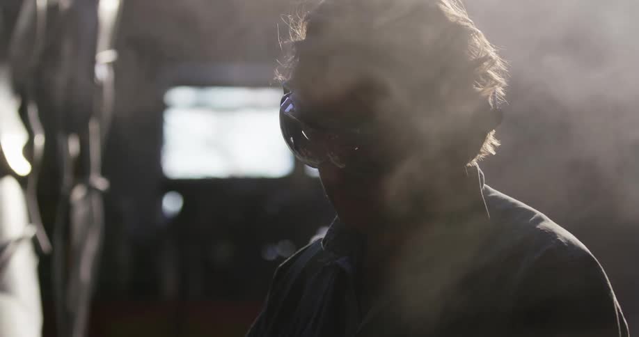 Steam rises around a man working with power tools