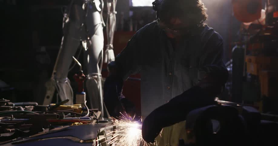 A man is welding in a garage