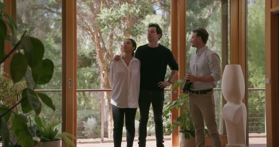 Two men and a woman look at the inside of a house