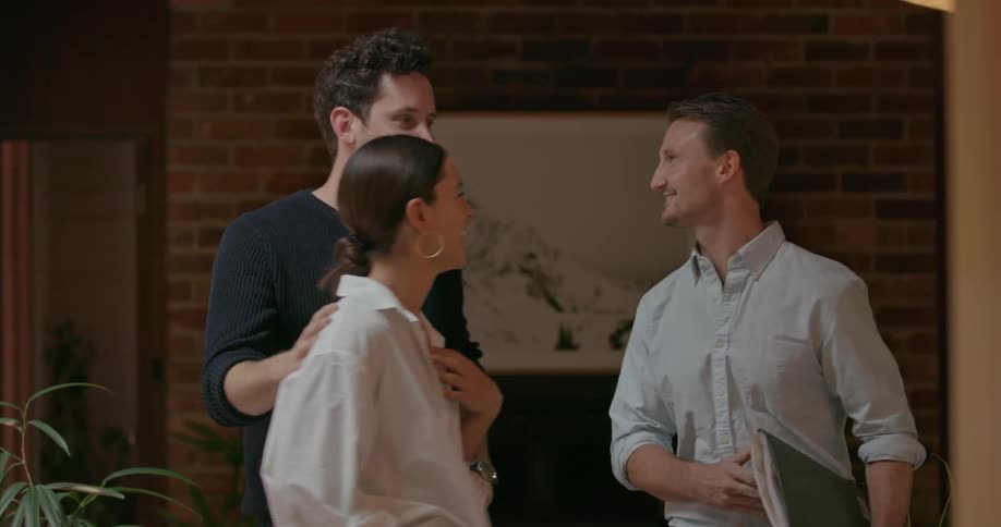 A couple talk with a man and laugh