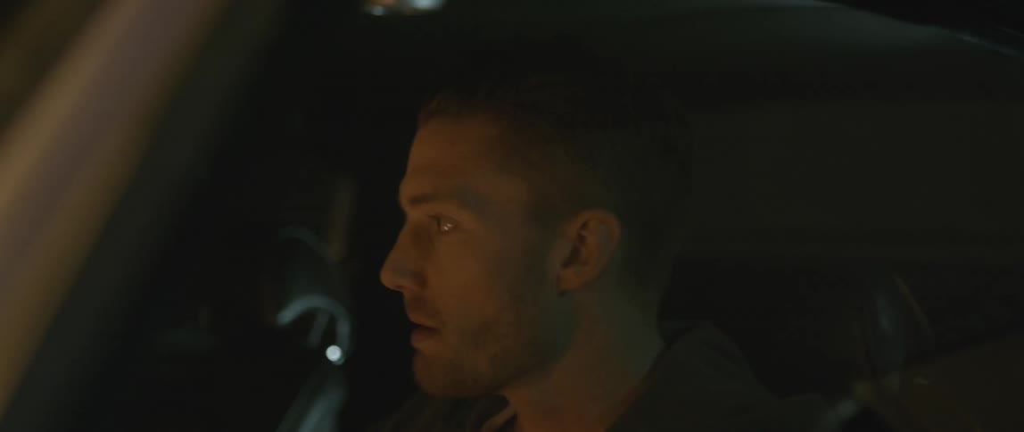 A man is in a car at night