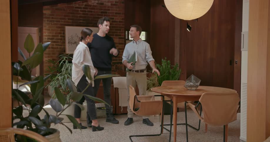 A couple talk with a man in a home