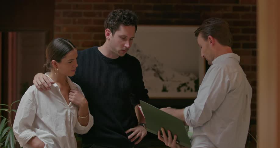 A young couple talks to a man with a notebook