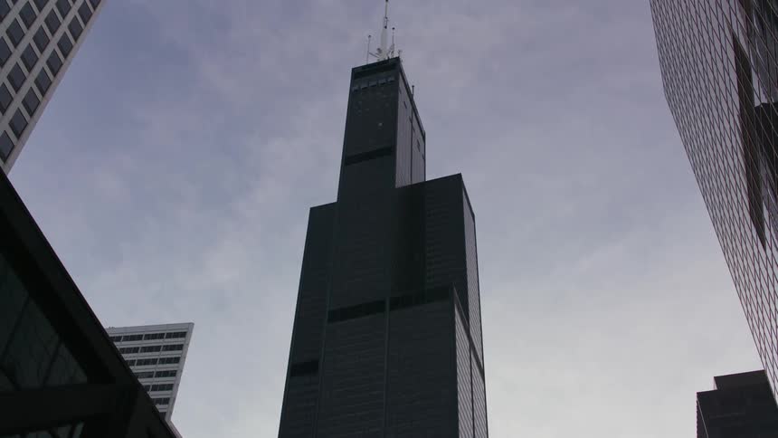 In the downtown area of a city the skyscrapers are very tall with antennas on the roofs