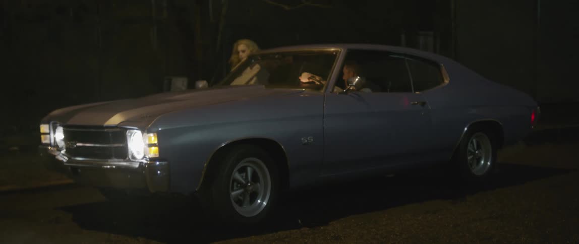 A woman jumps into a gray car