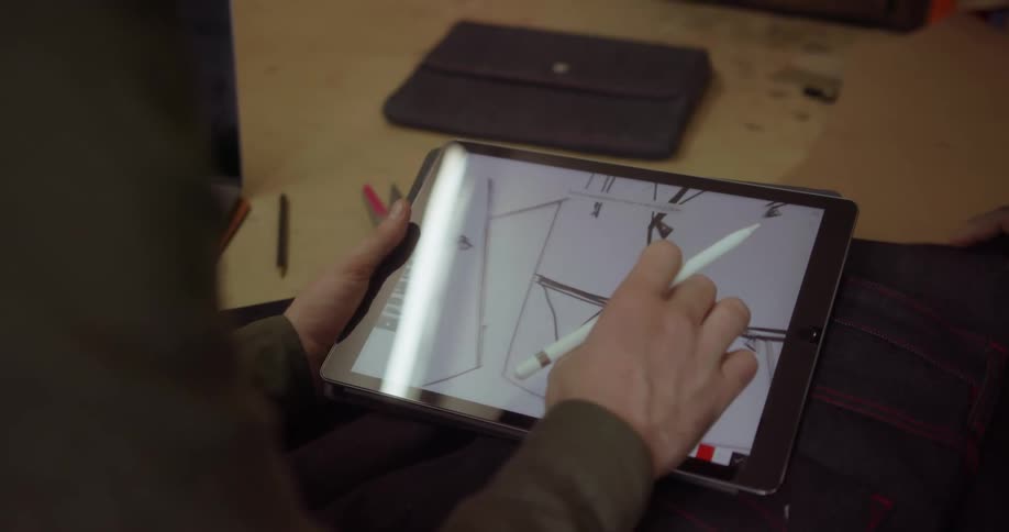A fashion designer works on a tablet