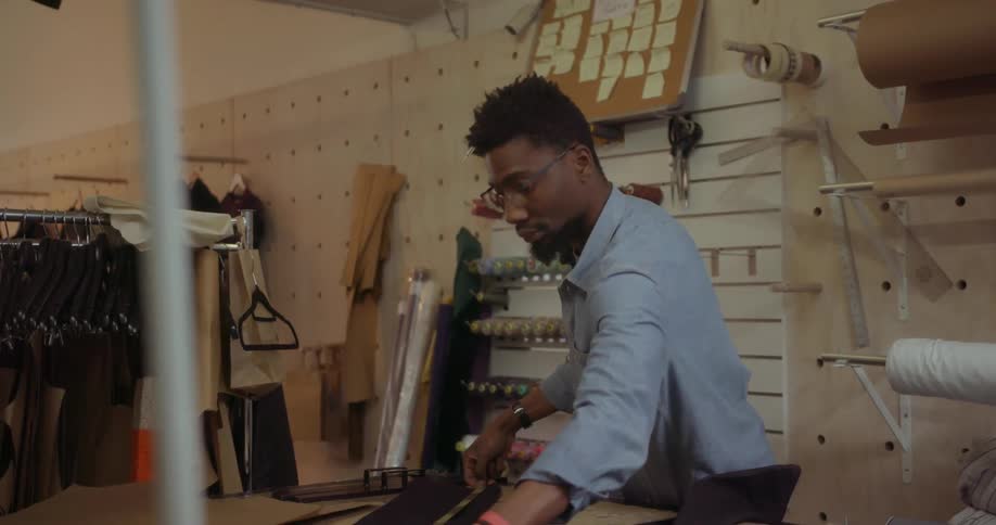 A fashion designer measures a piece of fabric