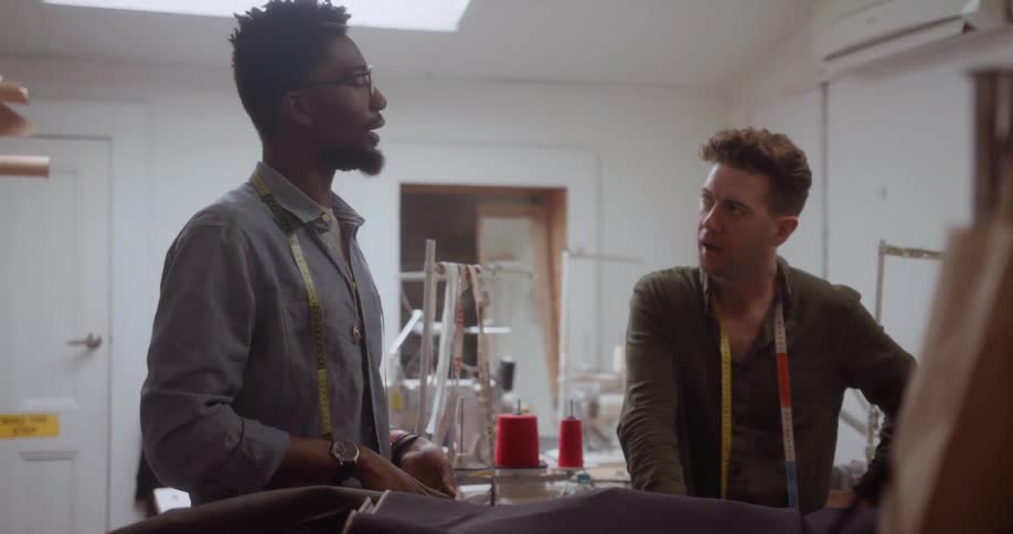 Two men talk together in a workplace