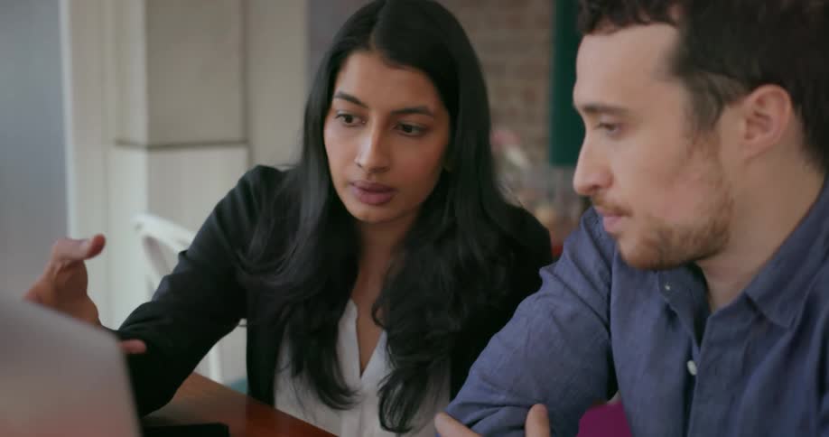 Man and woman talk as they look at a laptop screen