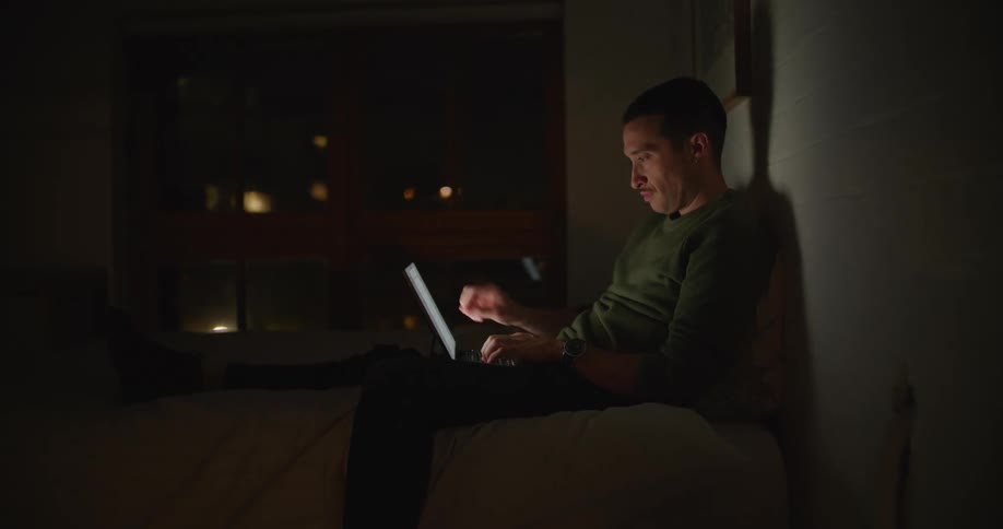 A man uses his laptop while sitting in a bean bag chair