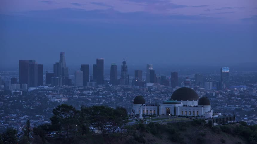 A timelapse shot of day turning into night that looks out at downtown LA over The Griffith Observatory