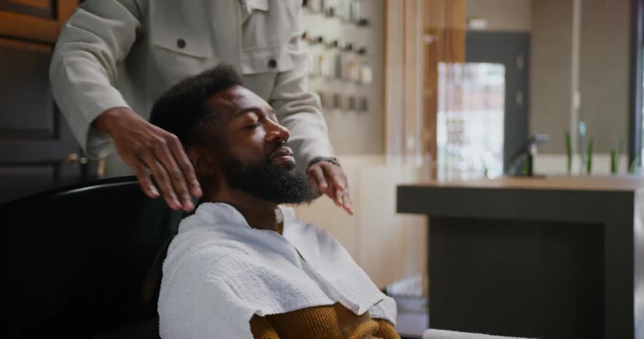 A man sits back in the barber shop