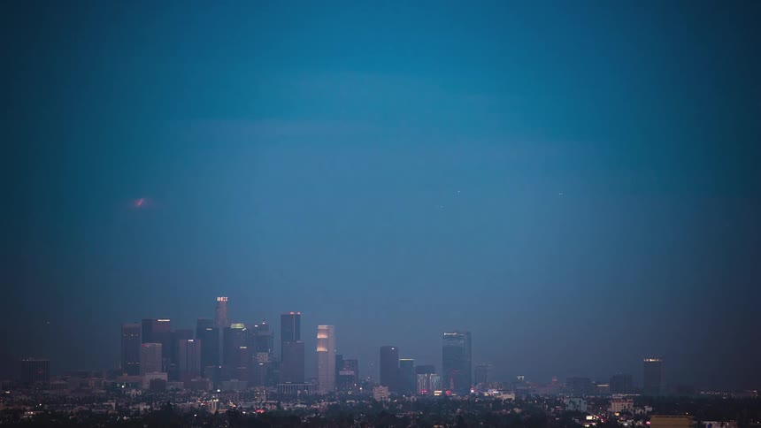 The moon rises above the city