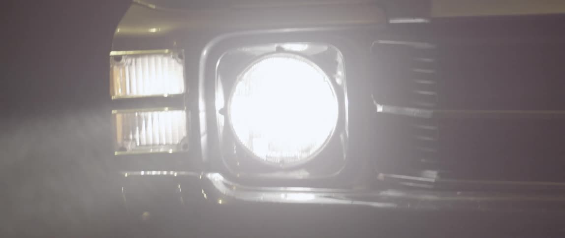 A car's headlight is on in the rain