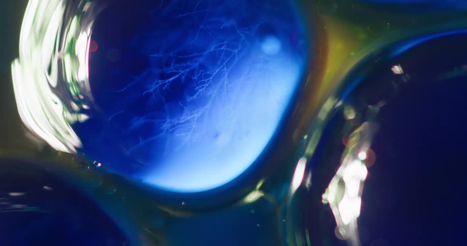 Abstract footage of a bright light shining on bubbles in gel