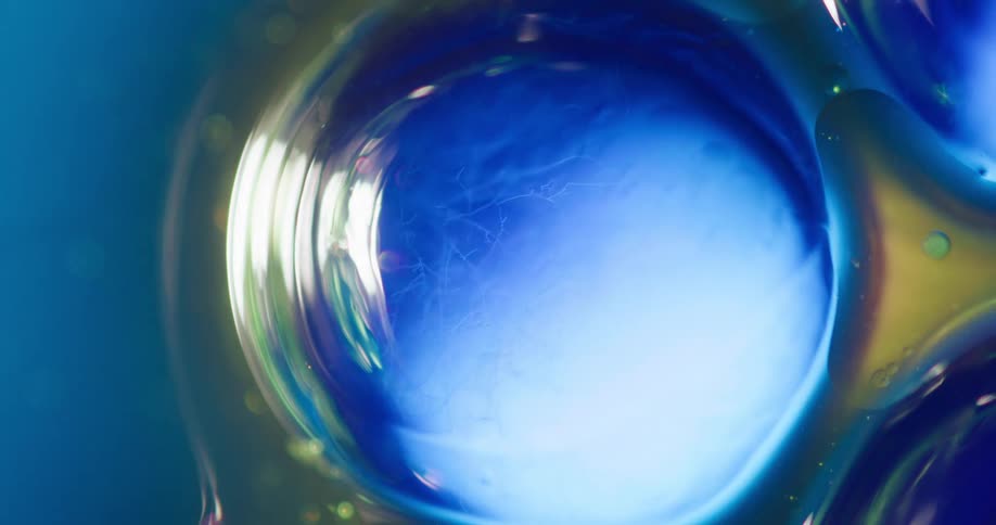 A light moves across a blue bubble with orange and green on the outside