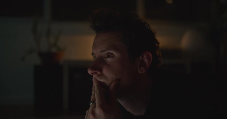 Man with ring uses laptop in dark room