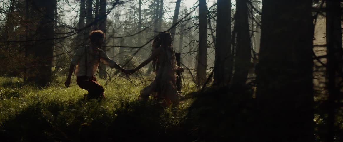 A man and woman running through a forest