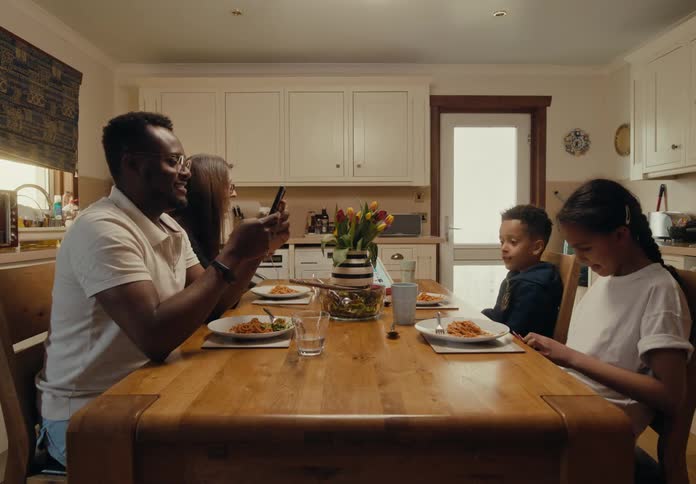 Timelapse of a family sitting down for a meal together at home
