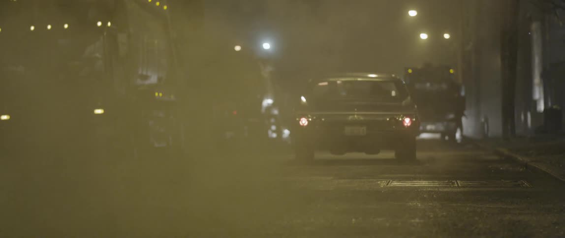 A car burns rubber as it peels off down an urban street