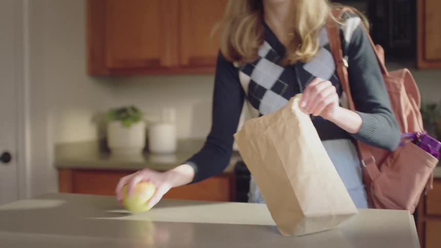 A woman is preparing her lunch in the kitchen on the counter