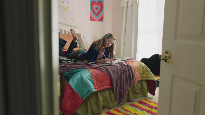 A girl is sitting in her bedroom during the day time