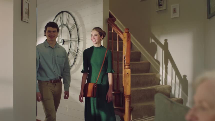 Couple wave as they walk into room where elderly woman is sitting