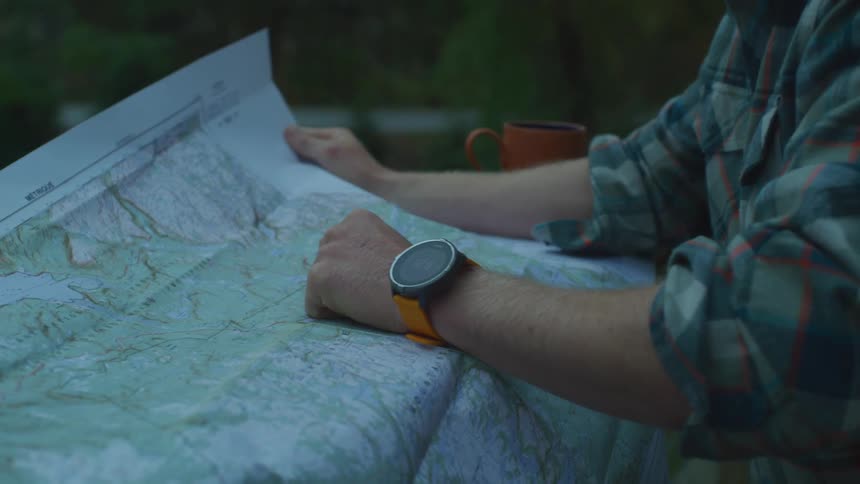 A man is sitting at a table with a map unfolded in front of him