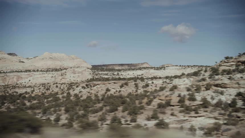 Bushes over the hills in the desert seen from the highway