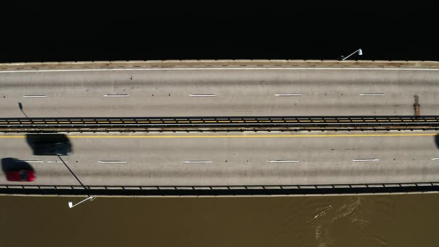 Traffic crosses muddy river during the day