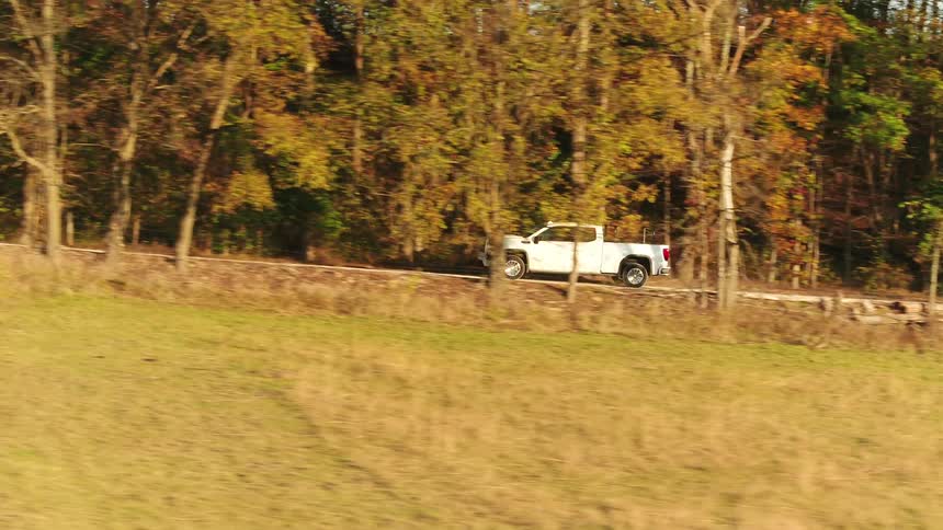 White truck driving on a rural road in the countryside