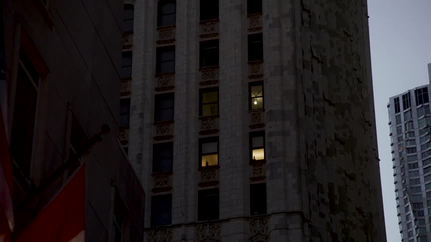 Lights shine from buildings window near street corner