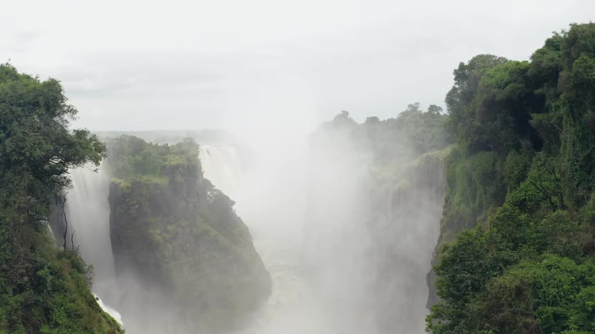 A waterfall drops over the edge of cliffs in several areas into the canyon below
