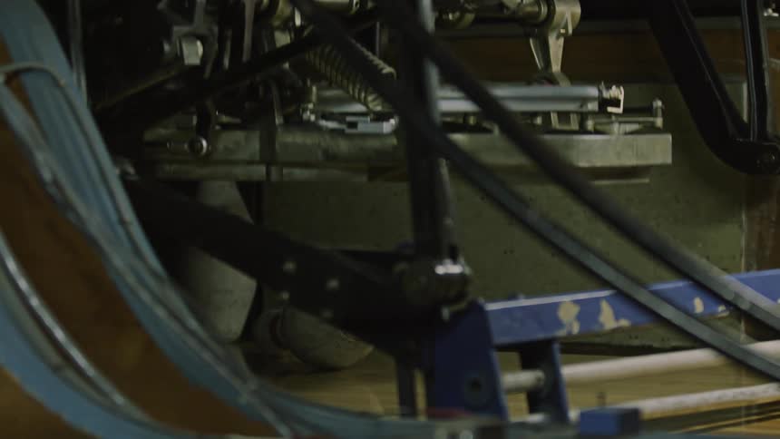 A vintage machine resets the pins at the bowling alley after a ball knocks them down
