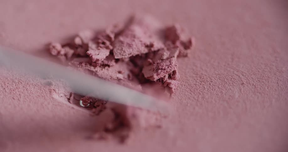 Tip of metal blade digs into caked tinted powder