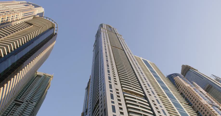 View looking up at tall skyscrapers towering high in a clear downtown sky