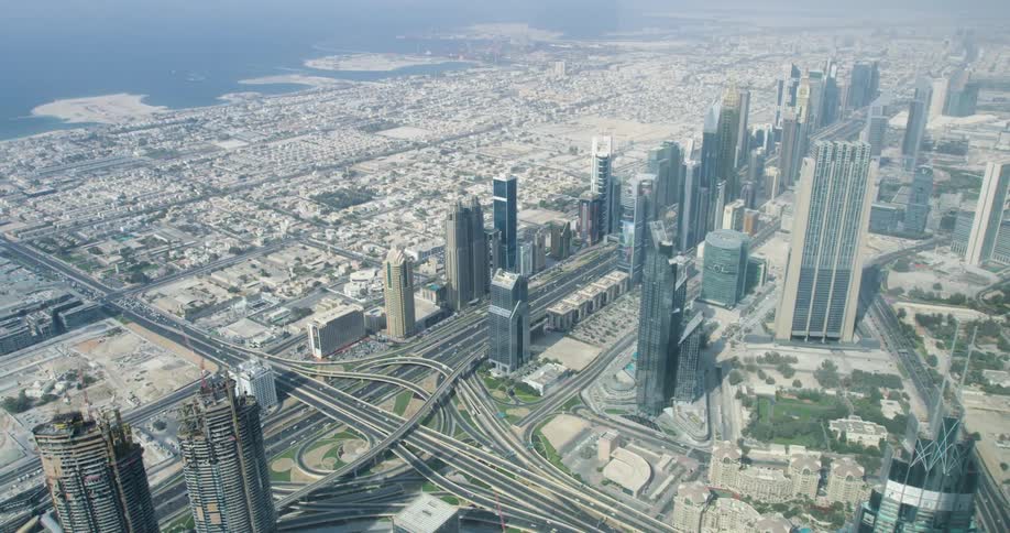 Aerial view of a huge metropolitan city on the coast with a highway intersection and tall skyscrapers