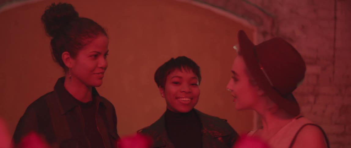 Three women smile and talk together