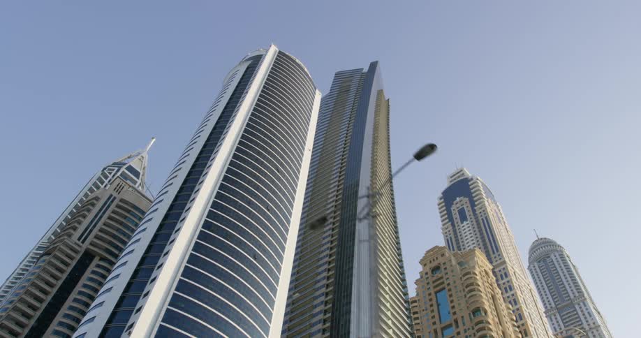Tall towers and skyscrapers reach high into a clear sky