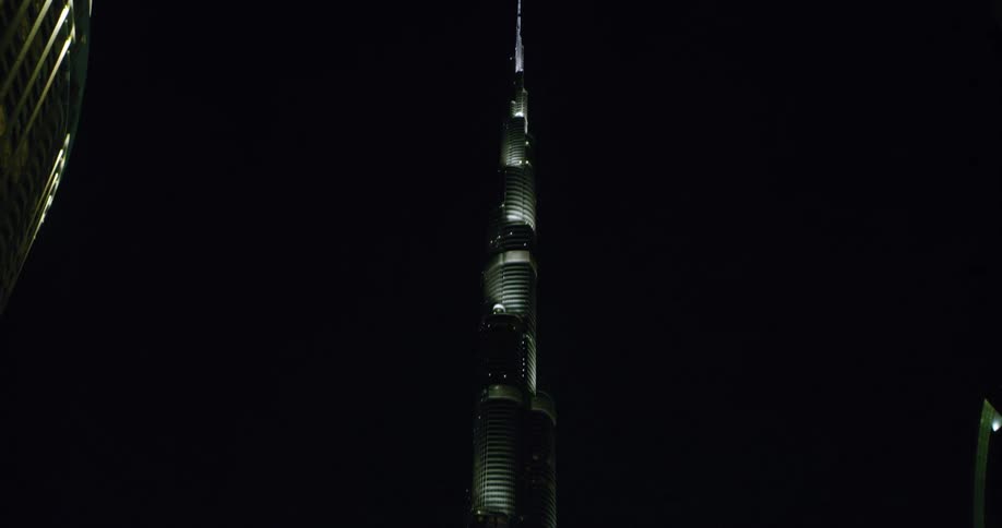 The tall building is lit at night