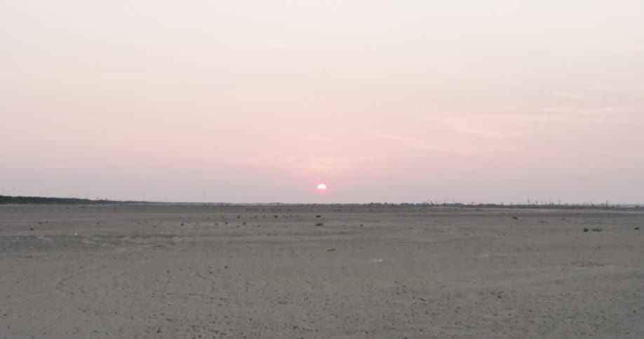 The sun sitting just above the horizon in the desert