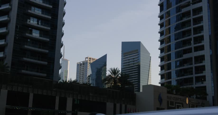 Exterior view of apartment buildings and palm trees at dusk