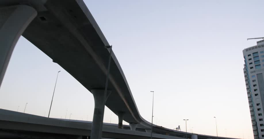 Cars traveling beneath an urban overpass in a city