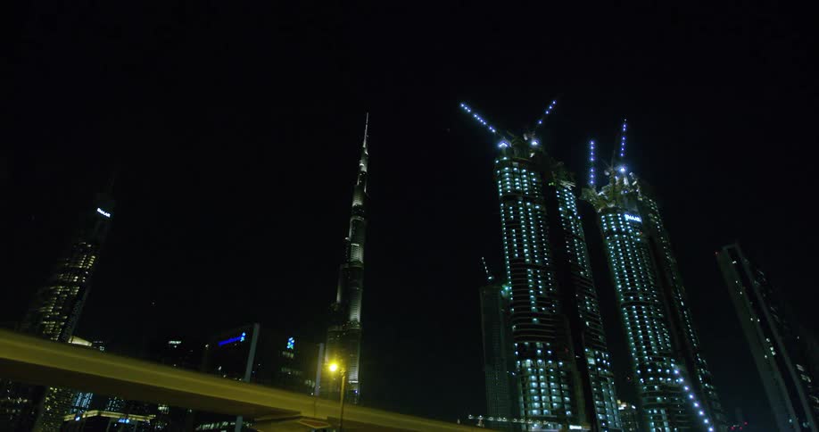 Downtown city lights shine against the darkness of the night sky