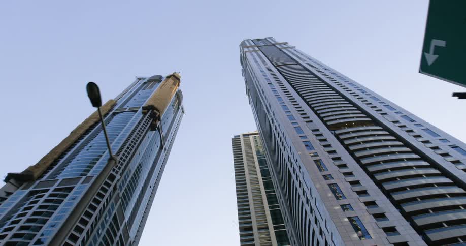 Tall towers and skyscrapers reach high into a clear sky