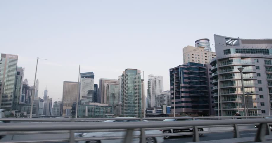 Skyscrapers loom over an overpass in a metropolis during the day